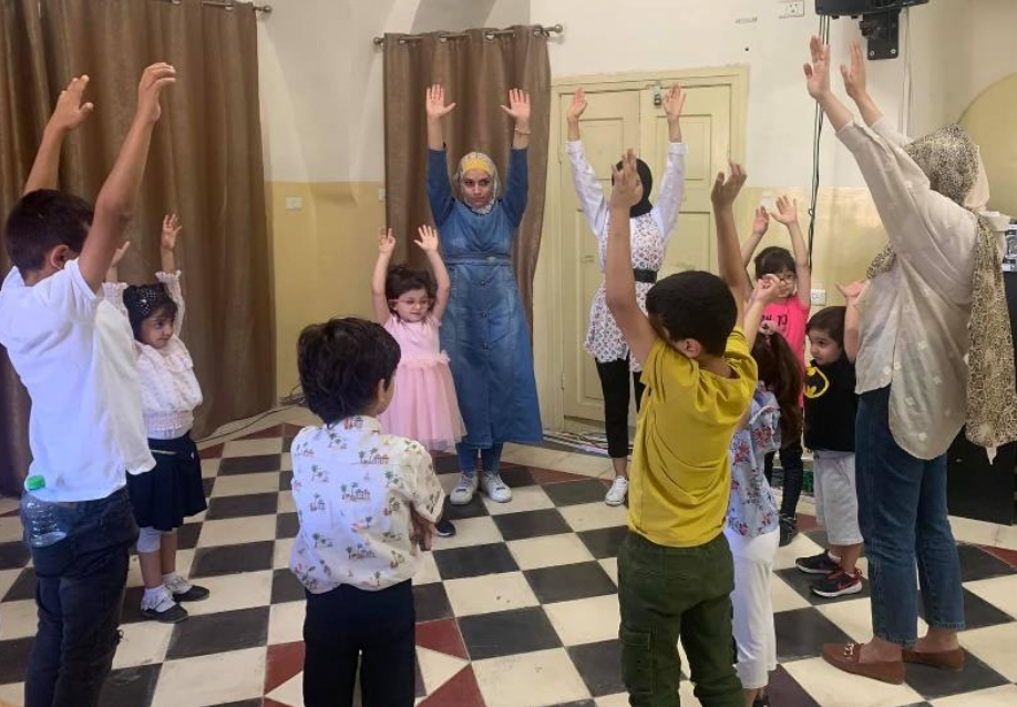 Group of Children in a circle with their hands raised